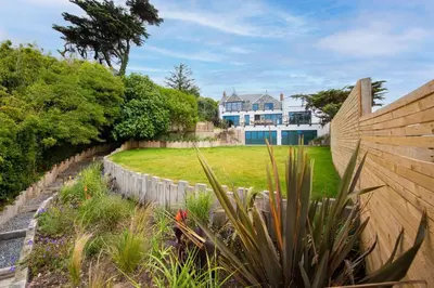 a garden with a fence and a house in the background at Watergate View in Porth
