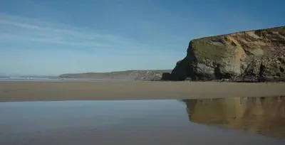 a beach with a large rock and some water at Watergate Horizon in Porth