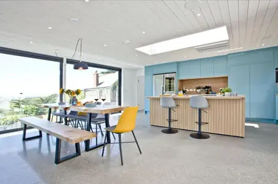 a dining room with a table and chairs and a kitchen at Watergate Horizon in Porth