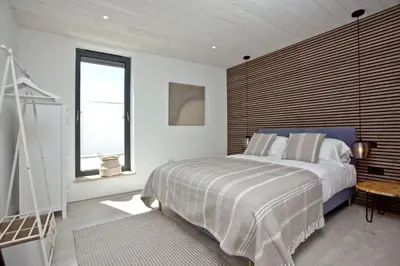a bedroom with a large bed with a wooden headboard at Watergate Horizon in Porth