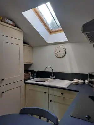 a kitchen with a skylight and a clock on the wall at The Granary -Trewen in Trewen