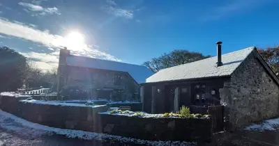 a stone building with the sun shining behind it at The Granary -Trewen in Trewen