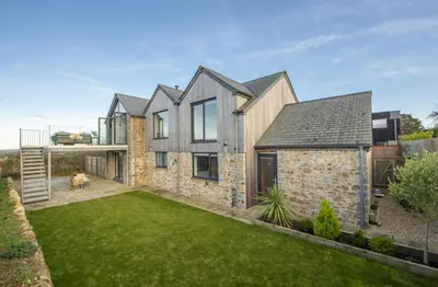 an exterior view of a house with a yard at Copper Tree in Newquay