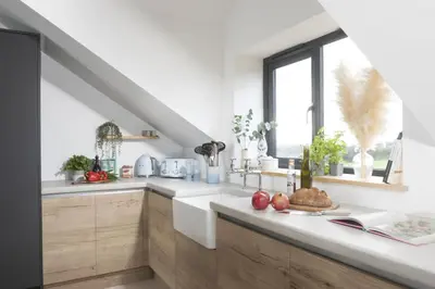a kitchen with white counters and a window at Copper Tree in Newquay