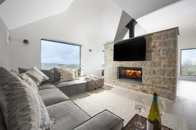a living room with a couch and a fireplace at Copper Tree in Newquay