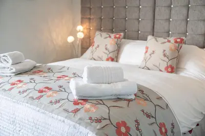 a bedroom with a bed with towels on it at Tregaddra Farm B&B in Helston