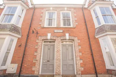 a brick building with two doors and two windows at The Attic, Tre-Pol-Pen in St Ives