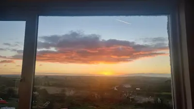 a view of a sunset from a window at Heatherbell in Carbis Bay