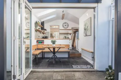 a kitchen and dining room with a table and a window at Premium 3BR Cottage Sauna EV Newquay in Newquay