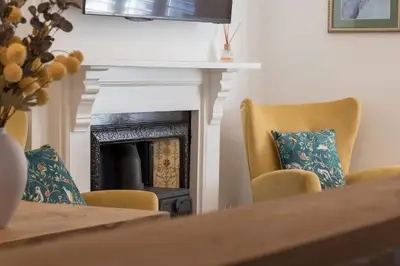 a living room with a fireplace and two chairs at Premium 3BR Cottage Sauna EV Newquay in Newquay