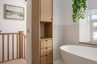 a bathroom with a bath tub and a window at Premium 3BR Cottage Sauna EV Newquay in Newquay