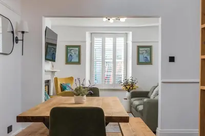 a living room with a wooden table and chairs at Premium 3BR Cottage Sauna EV Newquay in Newquay