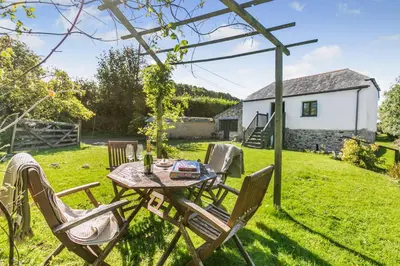 a table and chairs in the garden of a cottage at 1 Bed in St. Austell oc-b33396 in St Austell