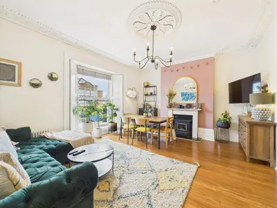 a living room with a couch and a table at Beautiful Georgian Apartment | Near Falmouth Town Centre | Walk to Shops + Pubs & Restaurants in Falmouth