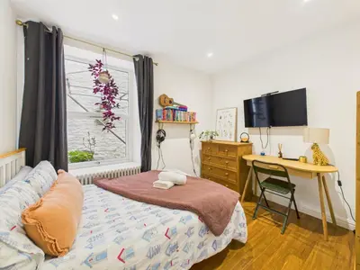 a bedroom with a bed and a desk and a window at Beautiful Georgian Apartment | Near Falmouth Town Centre | Walk to Shops + Pubs & Restaurants in Falmouth