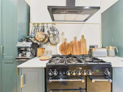 a kitchen with a stove top oven in a kitchen at Beautiful Georgian Apartment | Near Falmouth Town Centre | Walk to Shops + Pubs & Restaurants in Falmouth