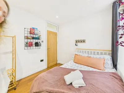 a bedroom with a bed with an orange pillow on it at Beautiful Georgian Apartment | Near Falmouth Town Centre | Walk to Shops + Pubs & Restaurants in Falmouth