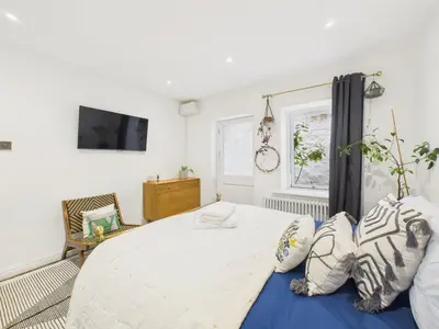 a bedroom with a large bed with pillows on it at Beautiful Georgian Apartment | Near Falmouth Town Centre | Walk to Shops + Pubs & Restaurants in Falmouth