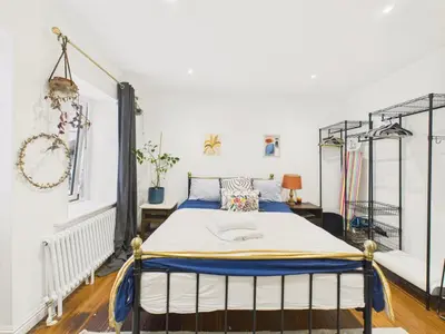 a bedroom with a bed in a white room at Beautiful Georgian Apartment | Near Falmouth Town Centre | Walk to Shops + Pubs & Restaurants in Falmouth