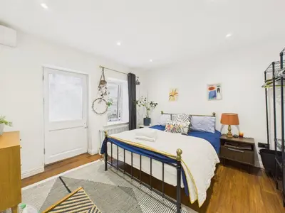a bedroom with a bed with blue sheets and a window at Beautiful Georgian Apartment | Near Falmouth Town Centre | Walk to Shops + Pubs & Restaurants in Falmouth