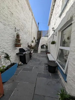 a stone walkway between two white buildings at Beautiful Georgian Apartment | Near Falmouth Town Centre | Walk to Shops + Pubs & Restaurants in Falmouth