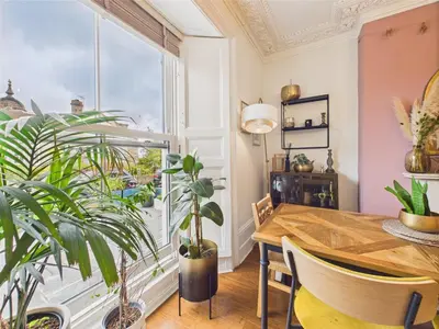 a dining room with a table and a large window at Beautiful Georgian Apartment | Near Falmouth Town Centre | Walk to Shops + Pubs & Restaurants in Falmouth