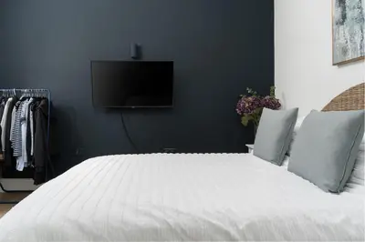 a bedroom with a white bed with a flat screen tv at Spacious House nr Castle Beach Parking & Sauna in Falmouth