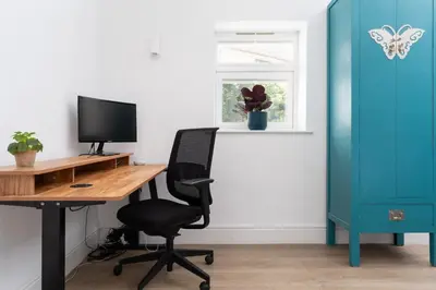 an office with a desk with a computer and a chair at Spacious House nr Castle Beach Parking & Sauna in Falmouth