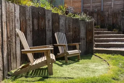 two chairs sitting in a yard next to a fence at Spacious House nr Castle Beach Parking & Sauna in Falmouth