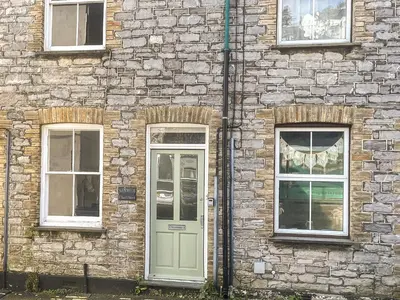 a brick building with a door and two windows at Kenwith Cottage in Looe