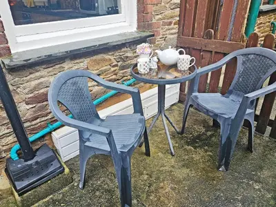 two chairs and a table in front of a window at Kenwith Cottage in Looe