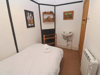 a bedroom with a bed and a sink in it at Pelican Cottage in St Ives