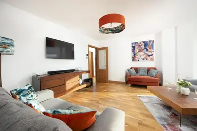a living room with a couch and a table at Ocean View, Mawgan Porth - Sea Views - Hot Tub - Free Parking & WiFi in Mawgan Porth