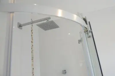 a shower with a shower head in a bathroom at Ocean View, Mawgan Porth - Sea Views - Hot Tub - Free Parking & WiFi in Mawgan Porth