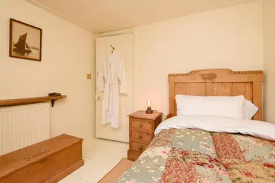 a bedroom with a bed and a robe hanging on a door at Ladye Park in Liskeard