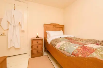 a bedroom with a bed and a dresser with a robe at Ladye Park in Liskeard