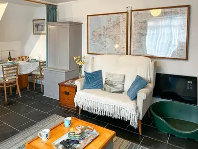 a living room with a couch and a tv at Orchard Cottage in Penzance