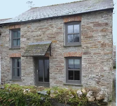 an old brick house with four windows at The White Cottage B&B in Saint Teath