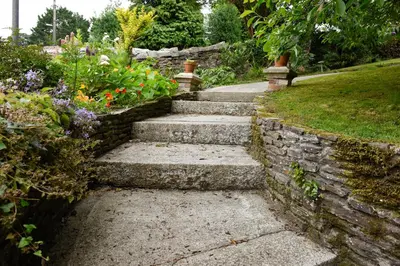 a set of stone steps in a garden with flowers at Cliftons Guest House in Truro