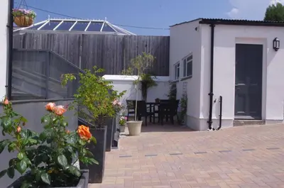 a patio with a fence and a house with a table at Cliftons Guest House in Truro