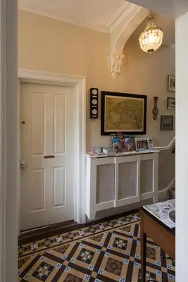 a hallway with a white door and a patterned floor at Cliftons Guest House in Truro