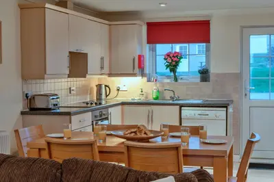 a kitchen and dining room with a table and chairs at Finest Retreats - 2 Chy Lowen in Newquay