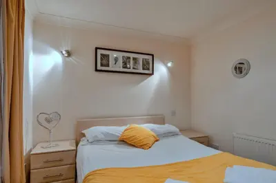 a bedroom with a bed with a yellow pillow at Finest Retreats - 2 Chy Lowen in Newquay