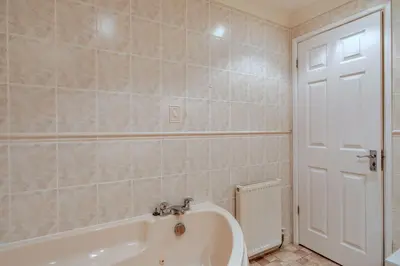 a bathroom with a tub and a white door at Finest Retreats - 2 Chy Lowen in Newquay