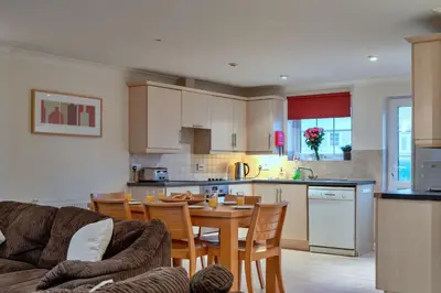 a kitchen with a table and chairs and a kitchen with a table and a kitchen at Finest Retreats - 2 Chy Lowen in Newquay