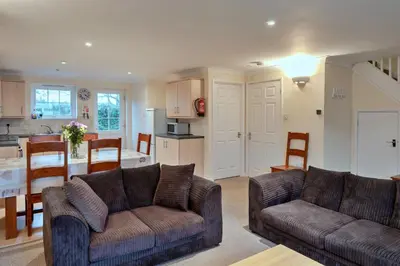 a living room with two couches and a kitchen at Finest Retreats - 20 Chy Lowen in Newquay