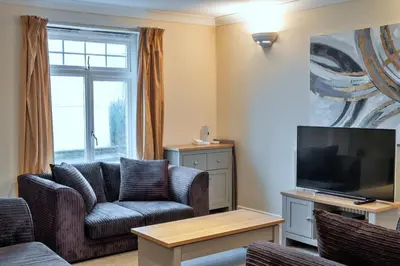 a living room with a couch and a tv at Finest Retreats - 20 Chy Lowen in Newquay