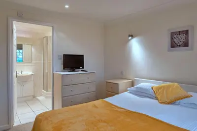a bedroom with a bed with a television and a bathroom at Finest Retreats - 20 Chy Lowen in Newquay
