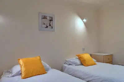two beds in a room with yellow pillows on them at Finest Retreats - 20 Chy Lowen in Newquay