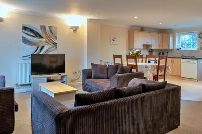 a living room with two couches and a kitchen at Finest Retreats - 20 Chy Lowen in Newquay